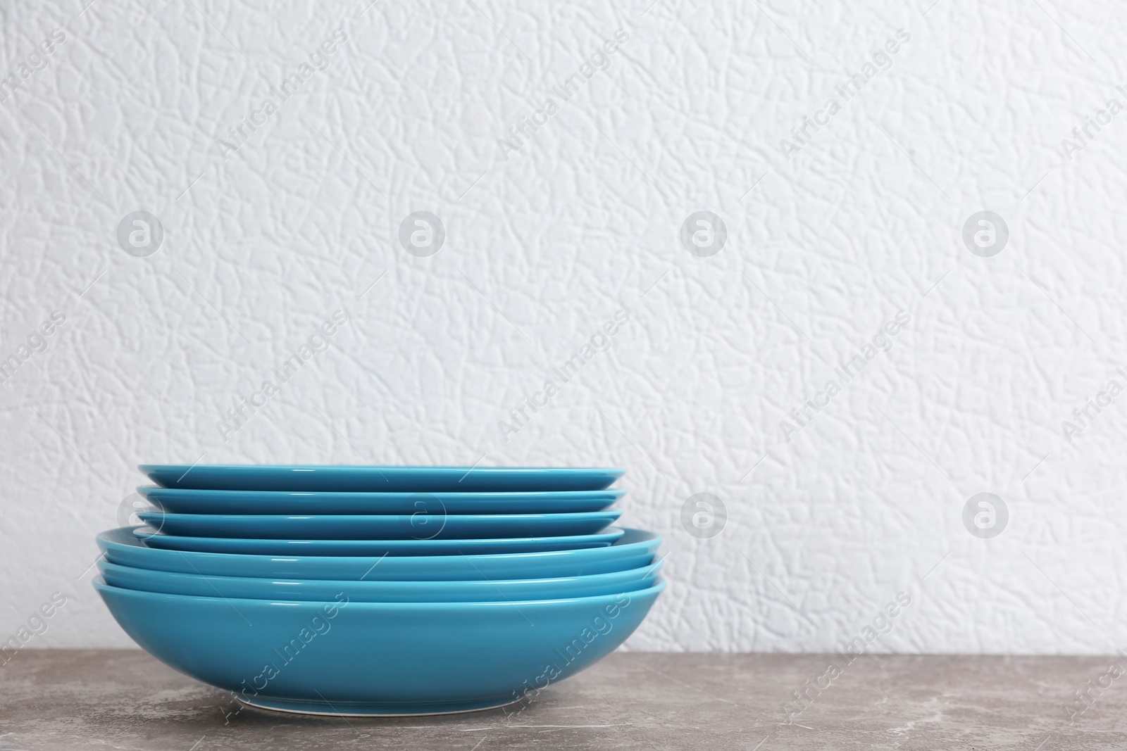 Photo of Stack of blue ceramic dishware on table