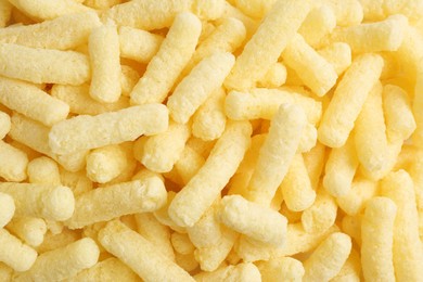 Tasty sweet corn sticks as background, top view