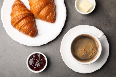 Flat lay composition with cup of coffee and croissants on grey background