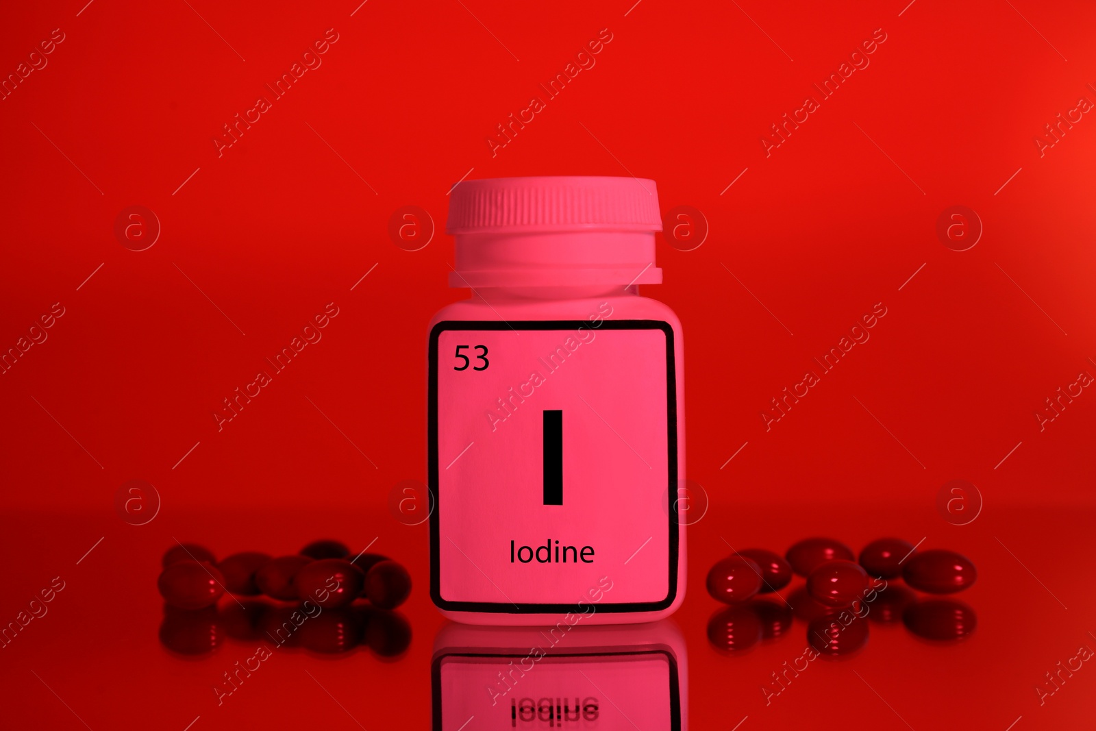 Photo of Bottle of medical iodine and pills on red background, color tone effect