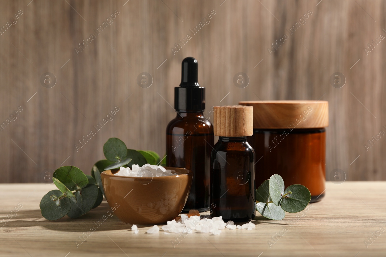 Photo of Composition with spa products and eucalyptus leaves on wooden table