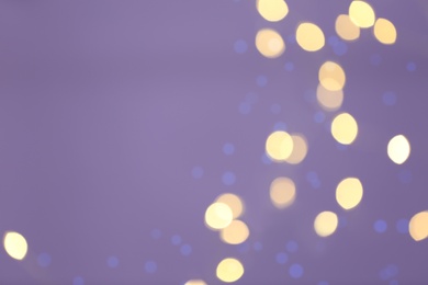 Photo of Beautiful blurred lights on violet background, bokeh effect. Space for text