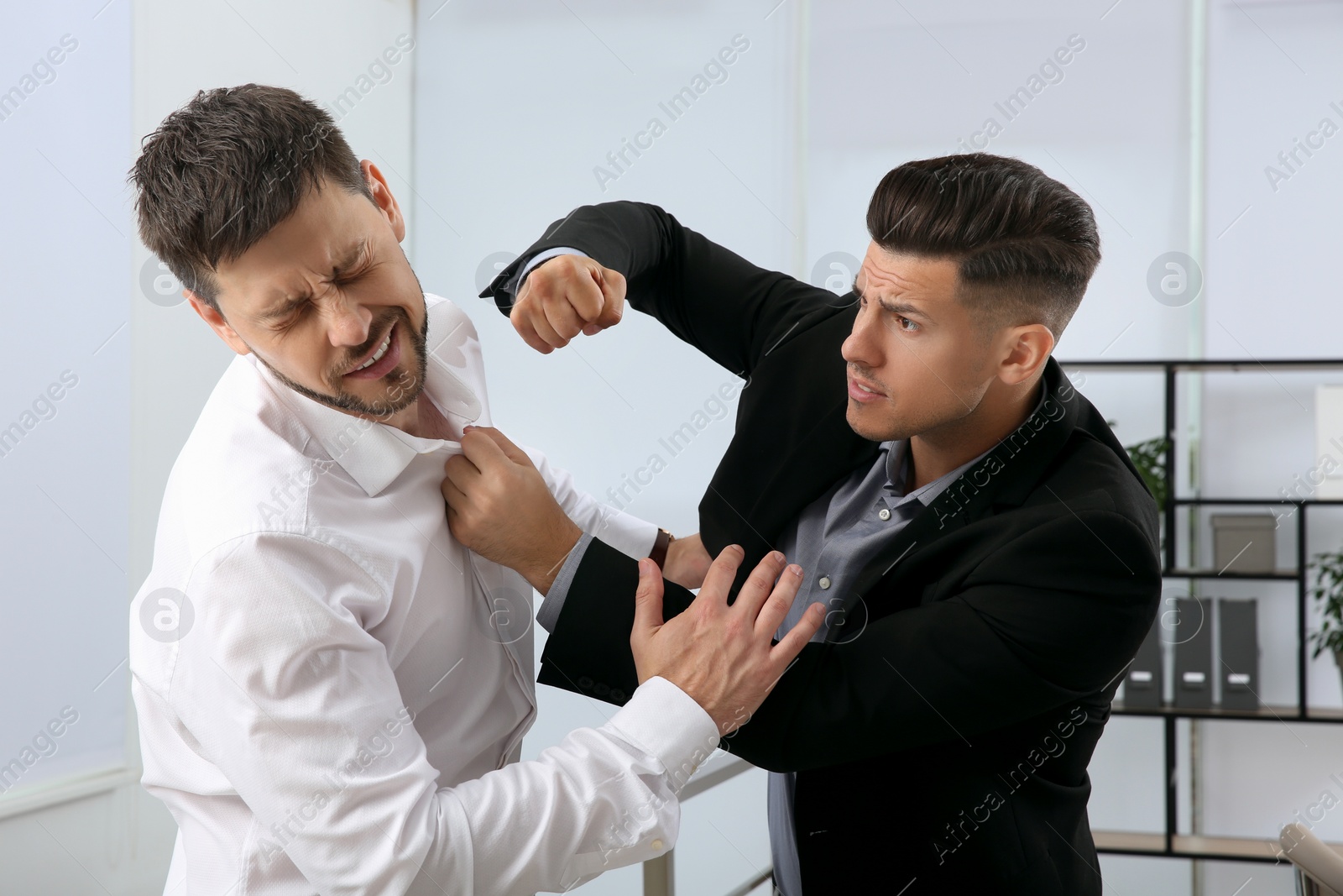 Photo of Emotional colleagues fighting in office. Workplace conflict