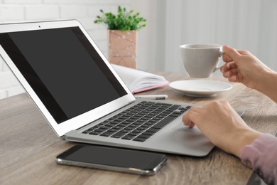 Woman working with laptop at table, closeup. Space for design