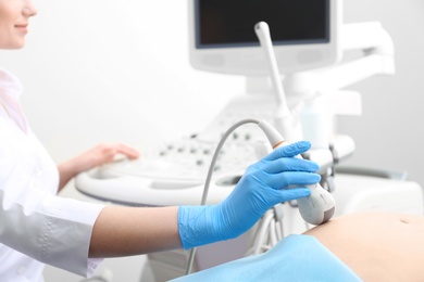 Pregnant woman undergoing ultrasound scan in clinic, closeup