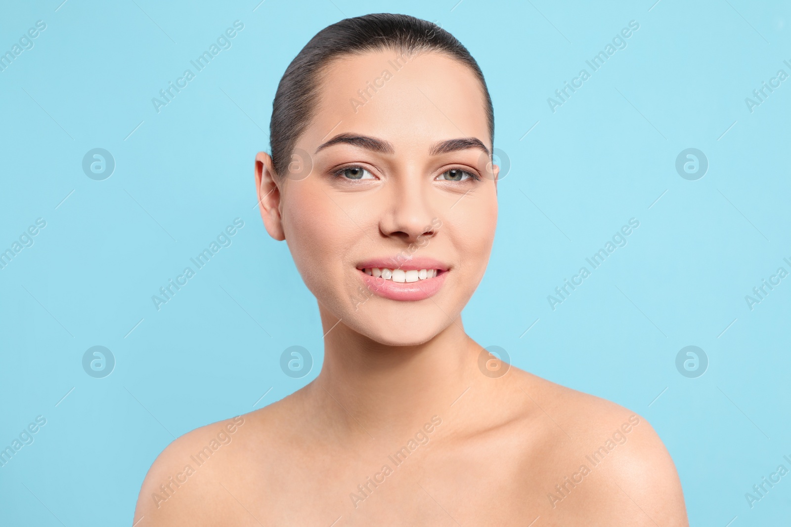 Photo of Portrait of young woman with beautiful face and natural makeup on color background