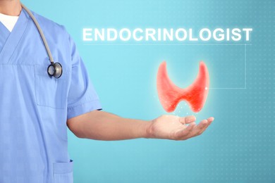 Image of Endocrinologist holding virtual thyroid gland on light blue background, closeup
