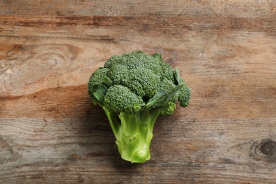 Photo of Fresh raw broccoli on wooden table, top view