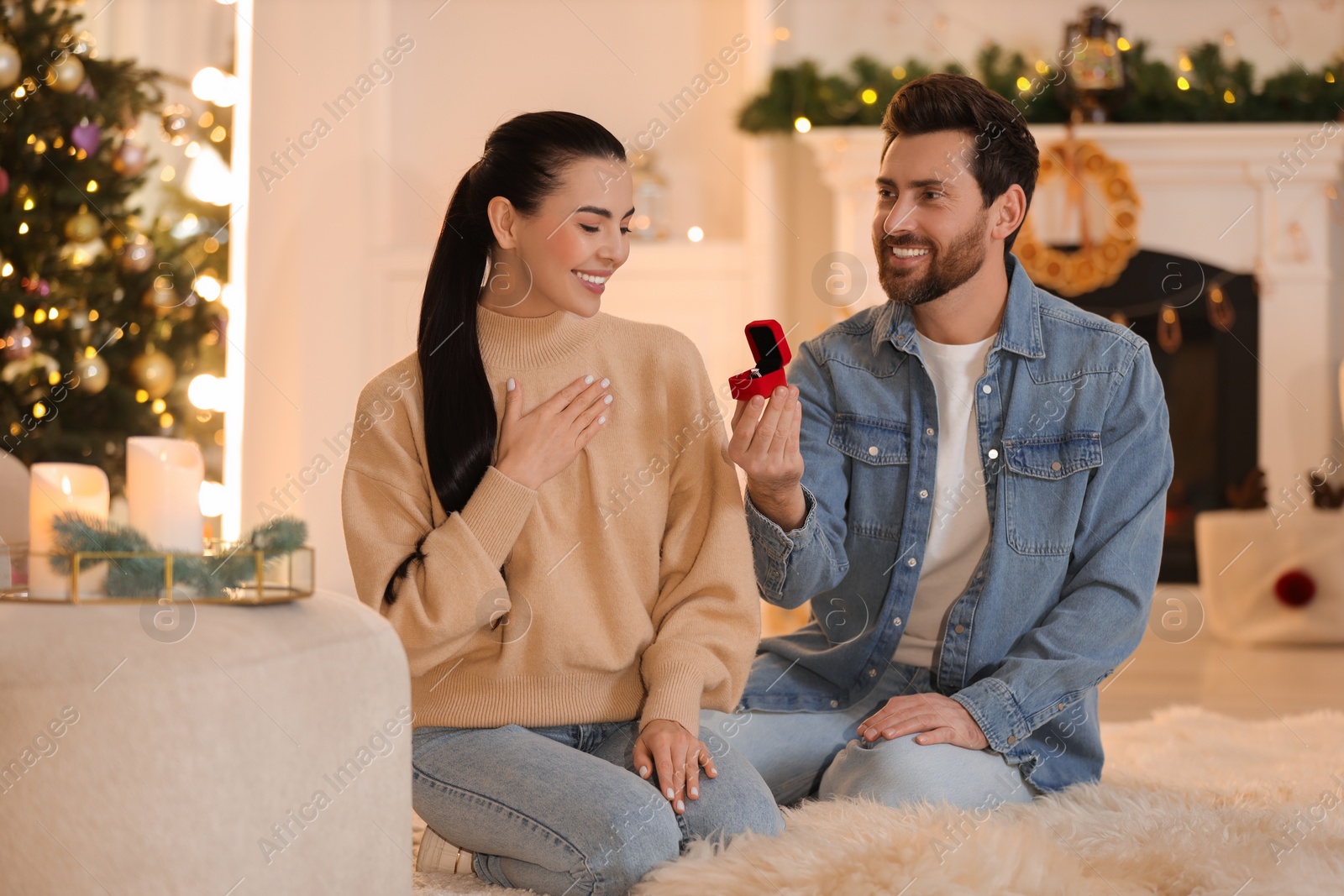 Photo of Man with engagement ring making proposal to his girlfriend at home on Christmas