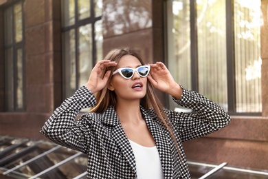 Young woman wearing stylish sunglasses on city street