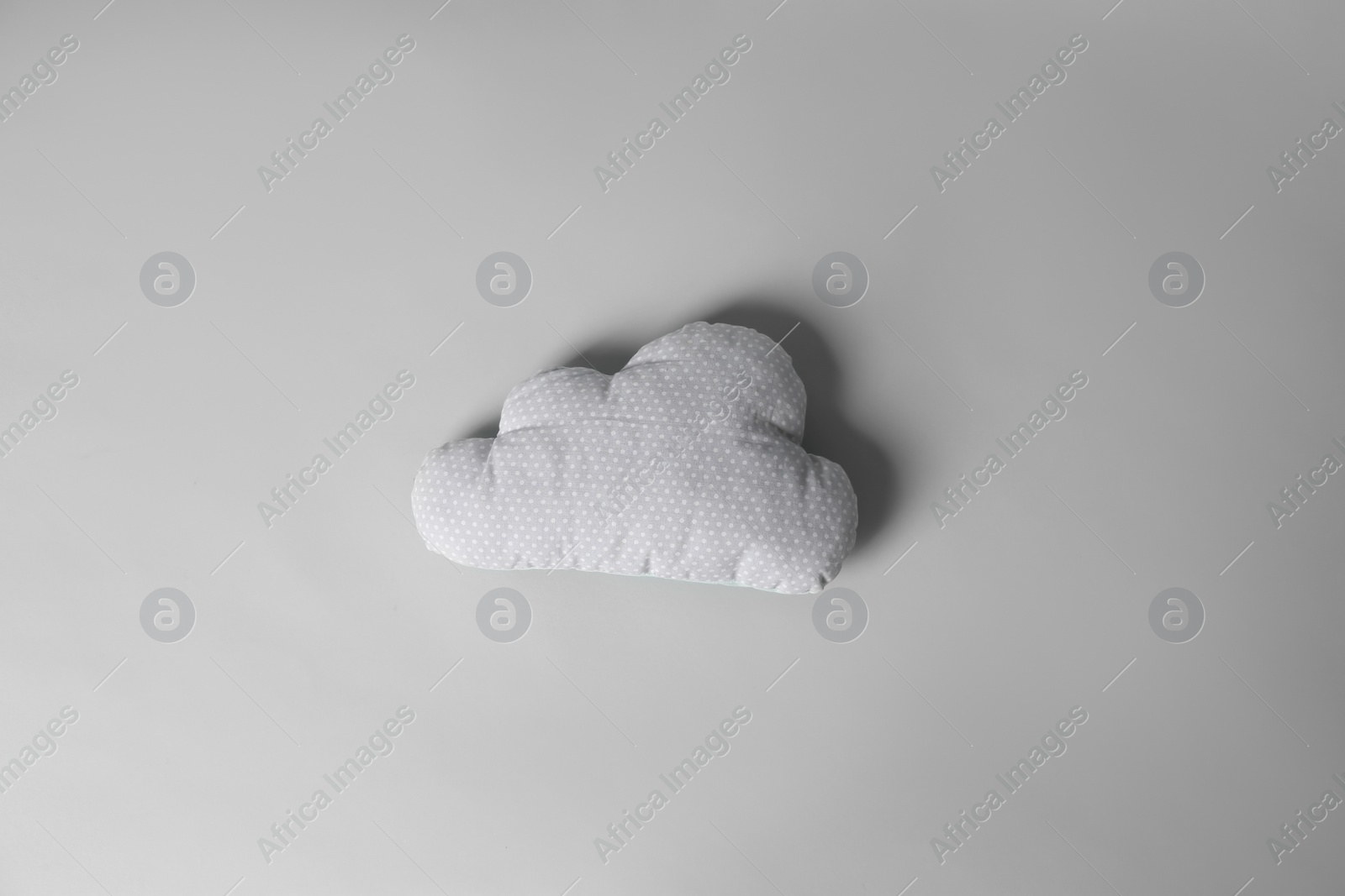 Photo of Soft pillow in shape of cloud on light background