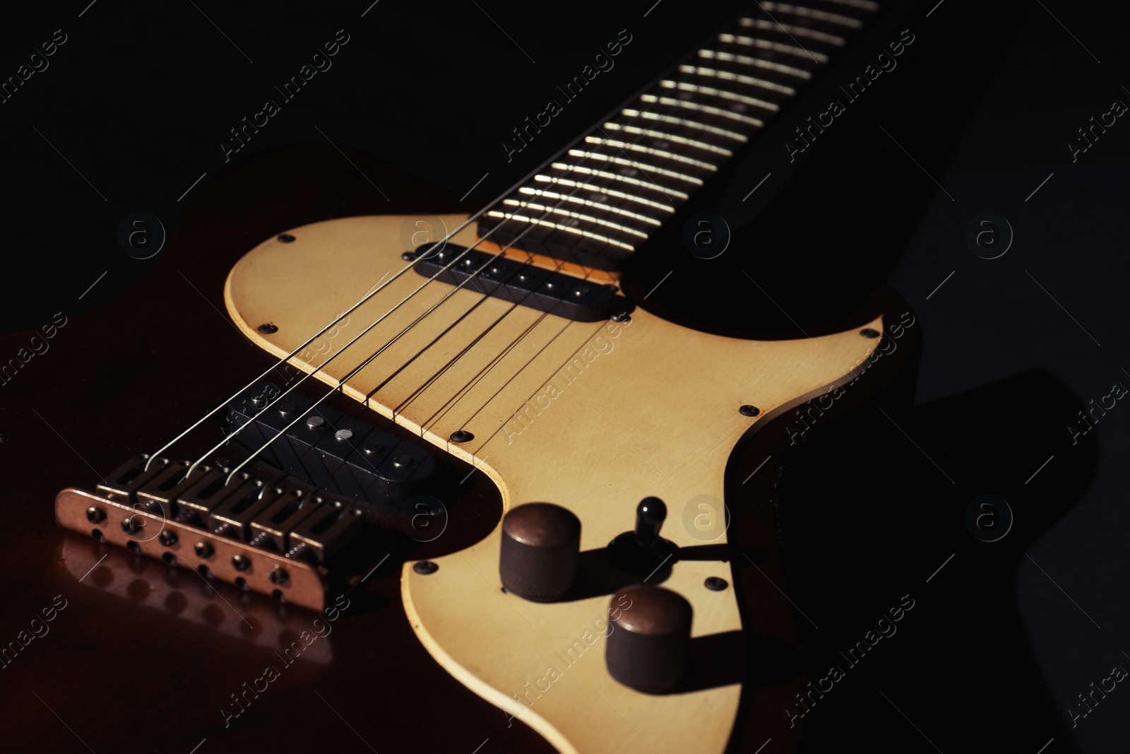 Photo of Electric guitar on black background, closeup. Musical instrument