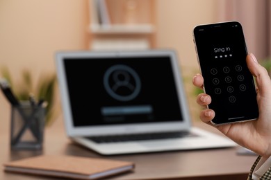 Woman holding smartphone with blocked screen indoors, closeup. Space for text