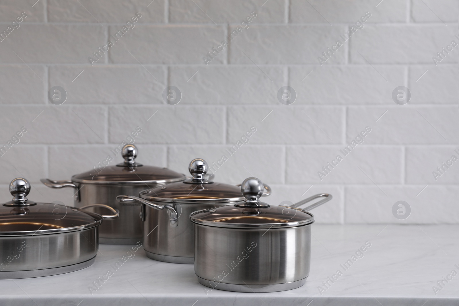 Photo of Set of new clean cookware on countertop in kitchen, space for text