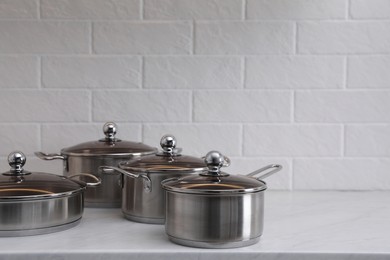 Photo of Set of new clean cookware on countertop in kitchen, space for text