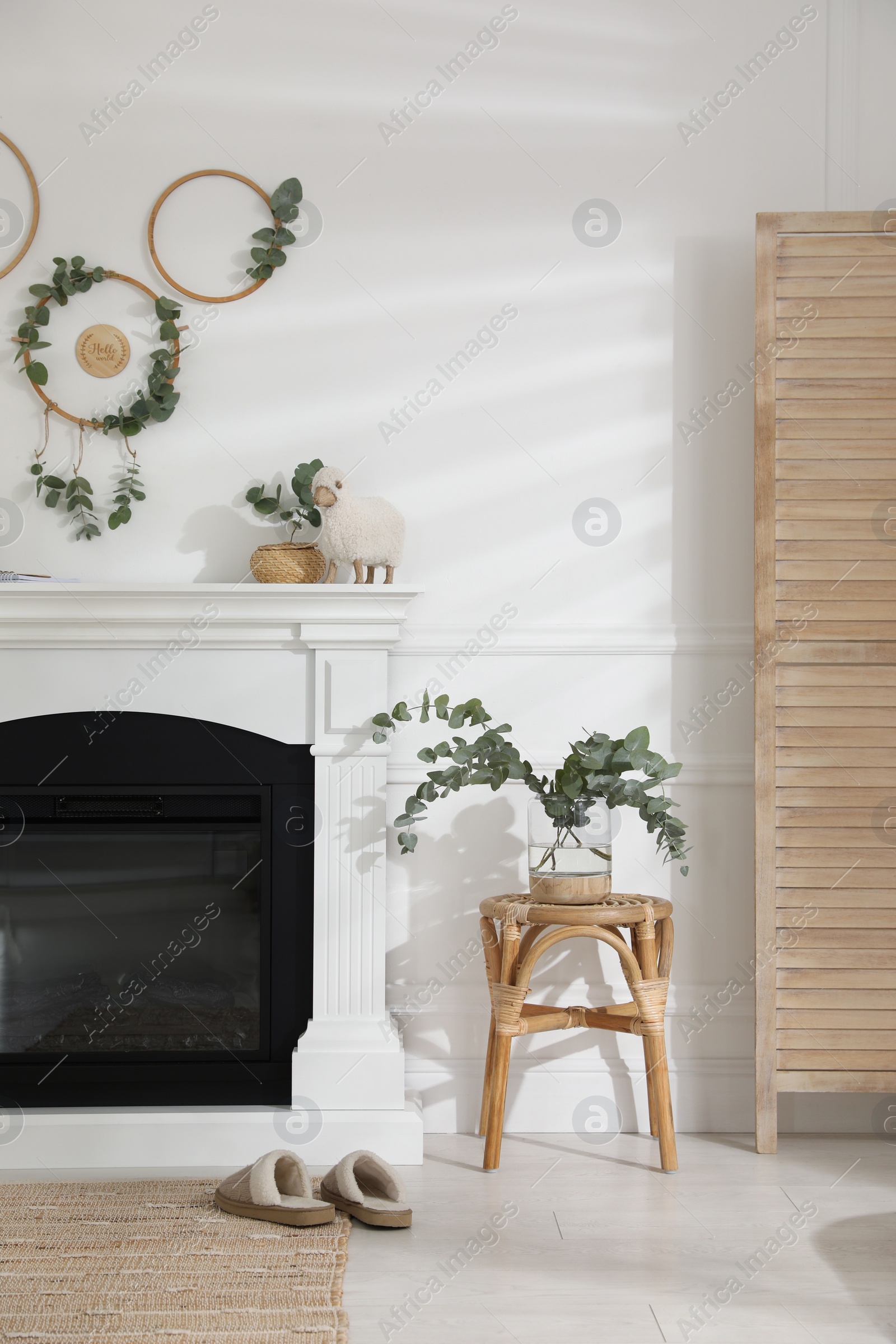 Photo of Stylish room with beautiful fireplace and eucalyptus branches