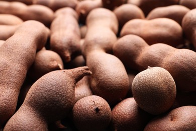 Photo of Delicious ripe tamarinds as background, closeup. Exotic fruit