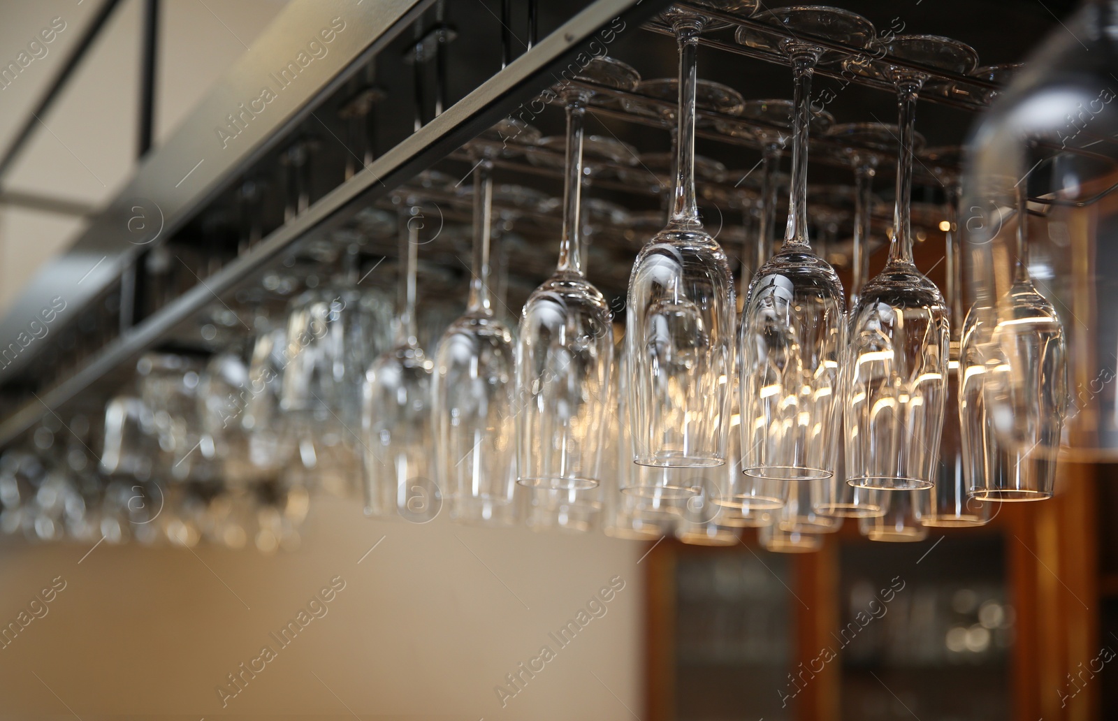 Photo of Many clean glasses on metal rack in restaurant