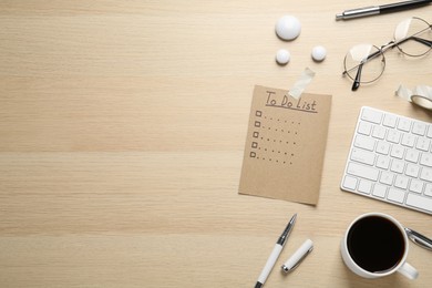 Flat lay composition with unfilled To Do list, cup of coffee and glasses on wooden table. Space for text