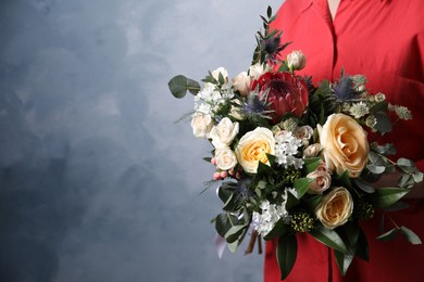 Photo of Woman with bouquet of beautiful roses on light blue background, closeup. Space for text