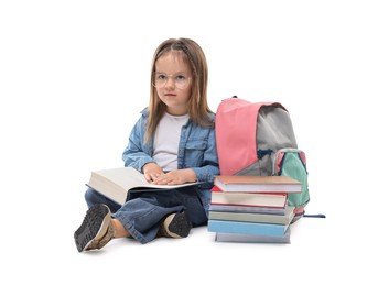 Photo of Cute little girl with books and backpack on white background