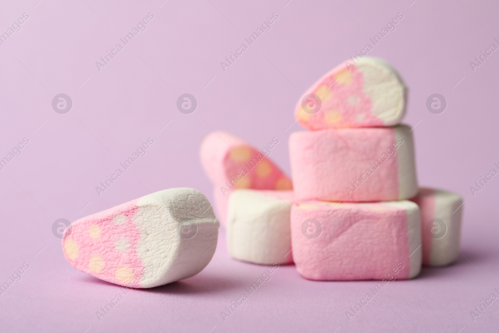 Photo of Pile of strawberry shaped marshmallows on pink background, closeup. Space for text