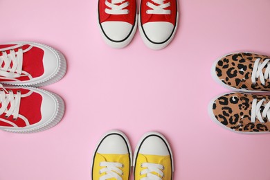 Photo of Different classic old school sneakers on pink background, flat lay. Space for text