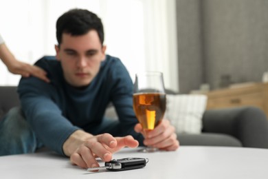 Photo of Woman stopping man from drunk driving, closeup. Don't drink and drive concept