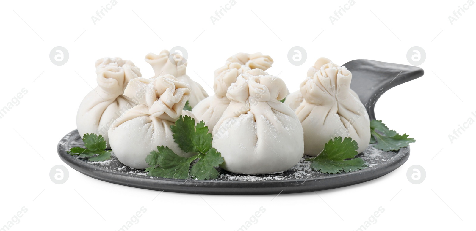 Photo of Board with uncooked khinkali (dumplings) and parsley isolated on white. Georgian cuisine