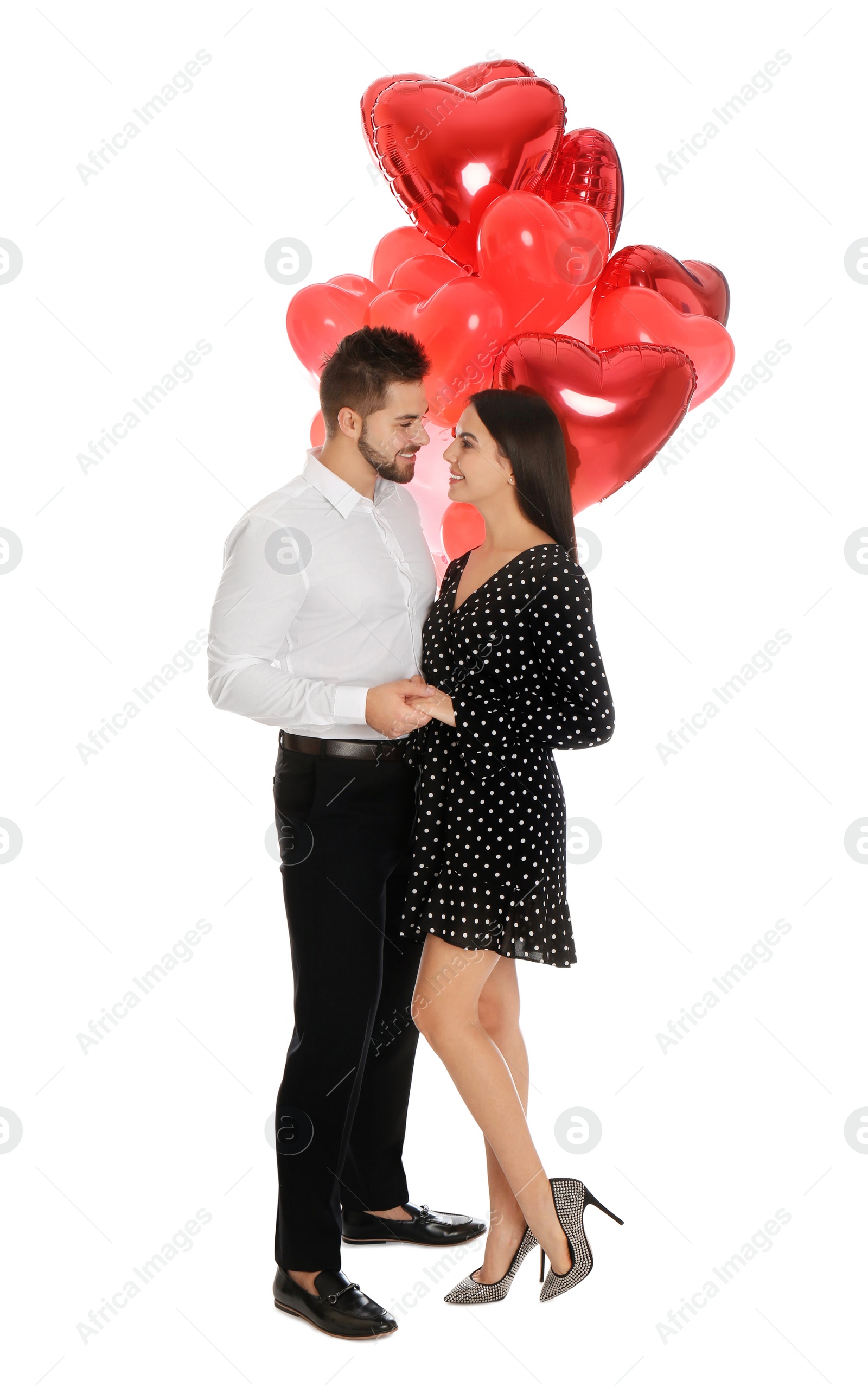 Photo of Happy young couple with heart shaped balloons isolated on white. Valentine's day celebration