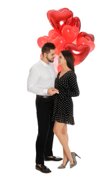 Photo of Happy young couple with heart shaped balloons isolated on white. Valentine's day celebration