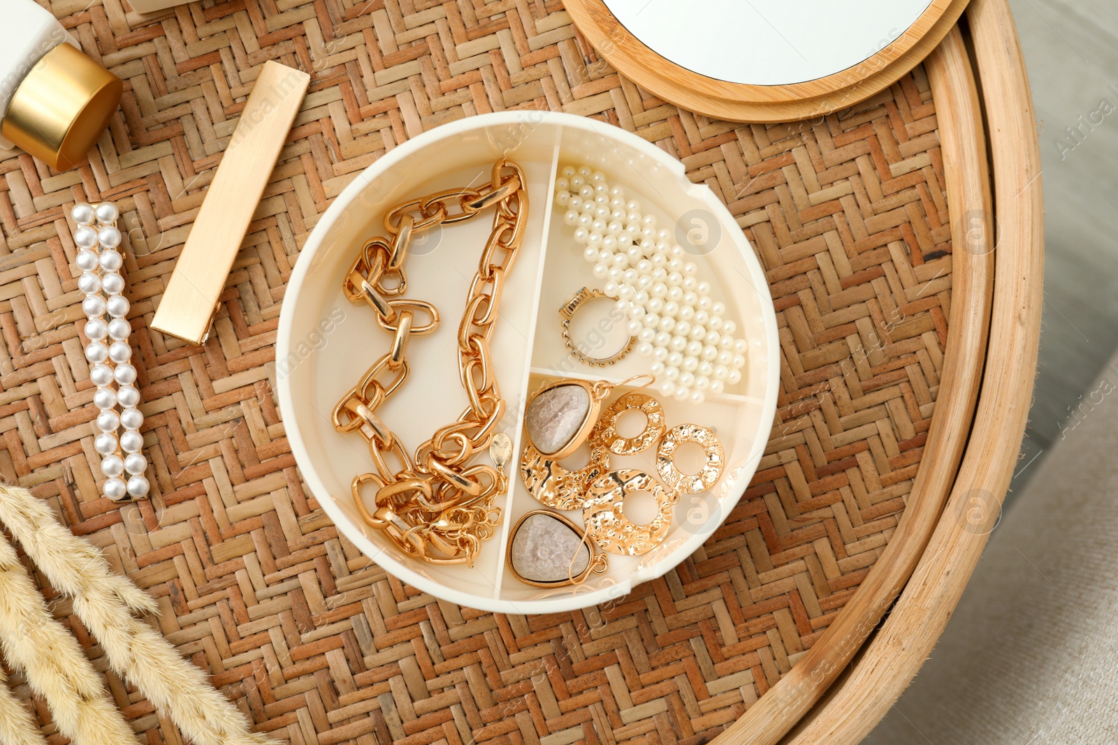 Photo of Stylish golden bijouterie on wicker table, top view