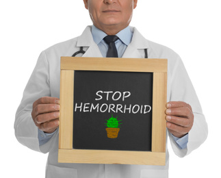 Doctor holding blackboard with phrase STOP HEMORRHOID on white background, closeup