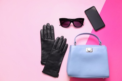 Flat lay composition with stylish black leather gloves and accessories on color background