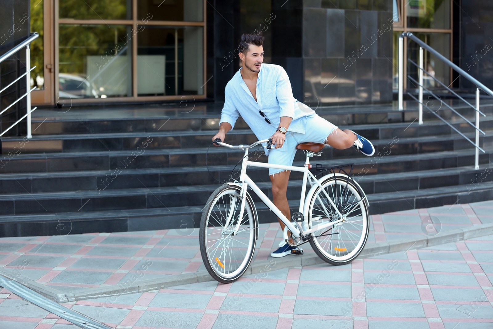 Photo of Handsome young hipster man with bicycle outdoors