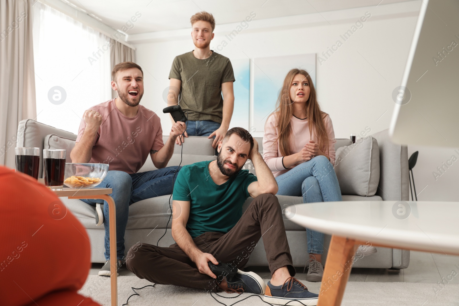 Photo of Emotional friends playing video games at home