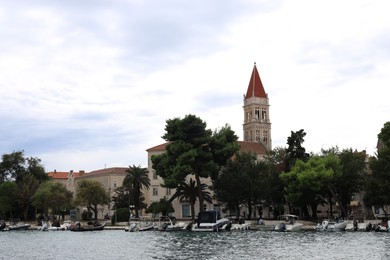 Photo of Trogir, Croatia - September 24, 2023: Picturesque view of town, moored boats and sea on cloudy day