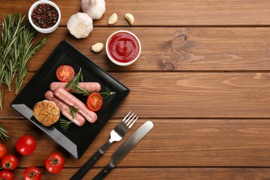 Flat lay composition with vegetarian sausages and vegetables on wooden table. Space for text