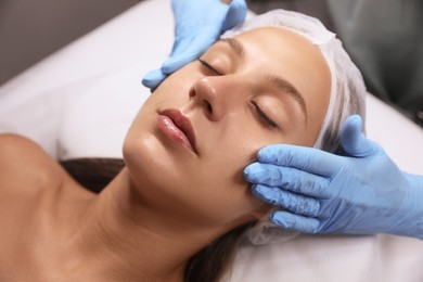 Young woman receiving facial massage in salon