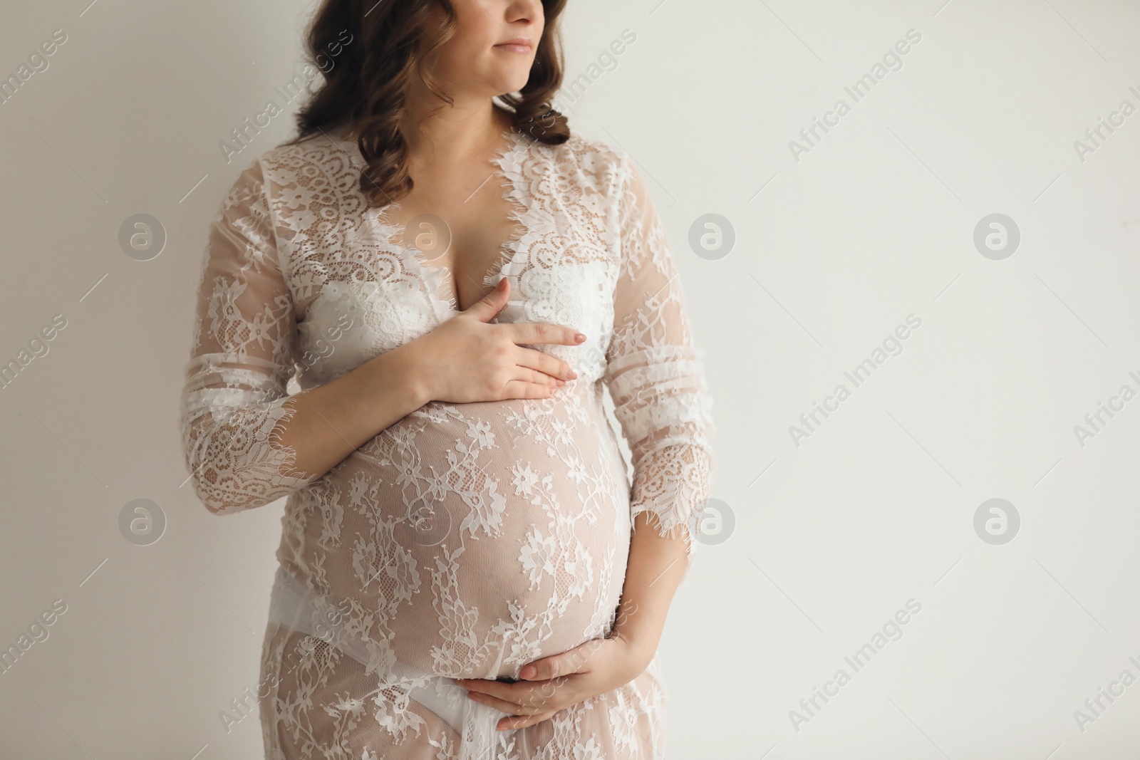 Photo of Young pregnant woman in elegant dress on light background