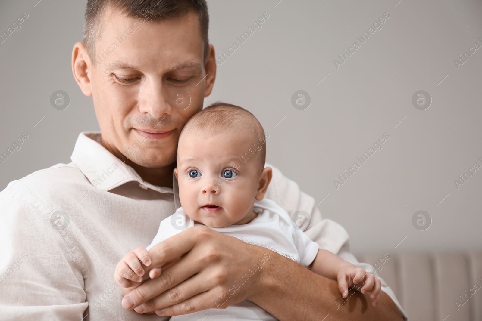 Photo of Happy father holding his cute baby at home, space for text