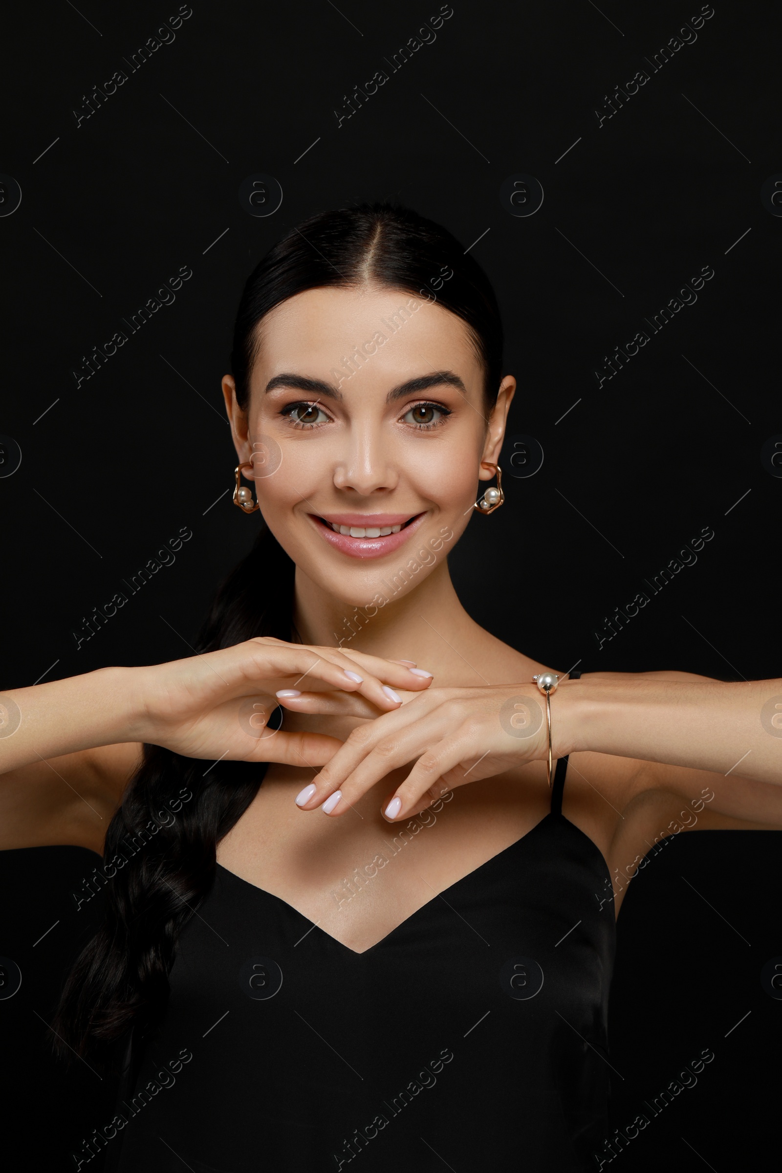 Photo of Young woman with elegant pearl jewelry on black background