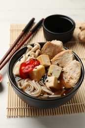 Photo of Delicious ramen served on white table, closeup. Noodle soup