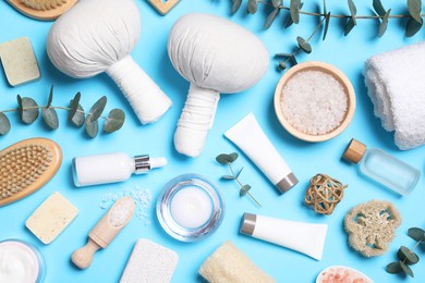 Photo of Flat lay composition with spa products and eucalyptus branches on light blue background