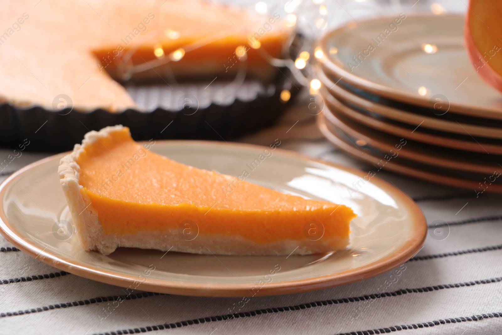 Photo of Plate with piece of fresh homemade pumpkin pie on table