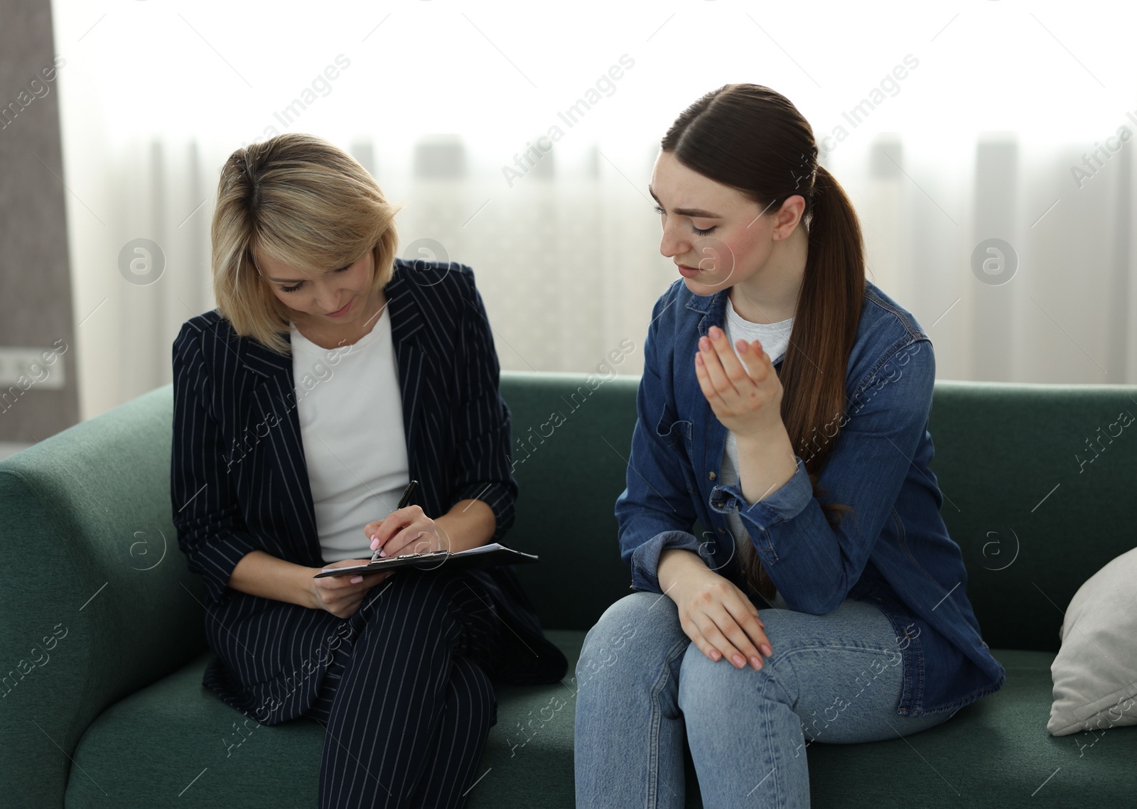 Photo of Psychotherapist working with patient on sofa in office