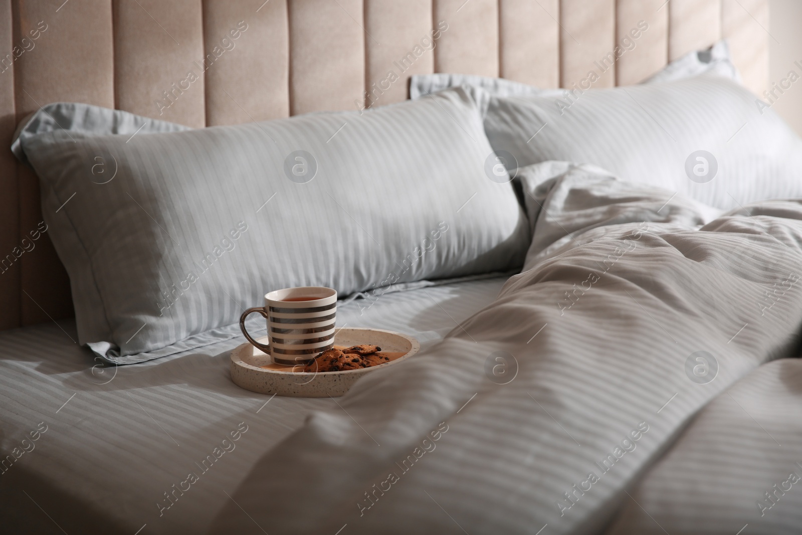 Photo of Tray with breakfast and soft blanket on bed