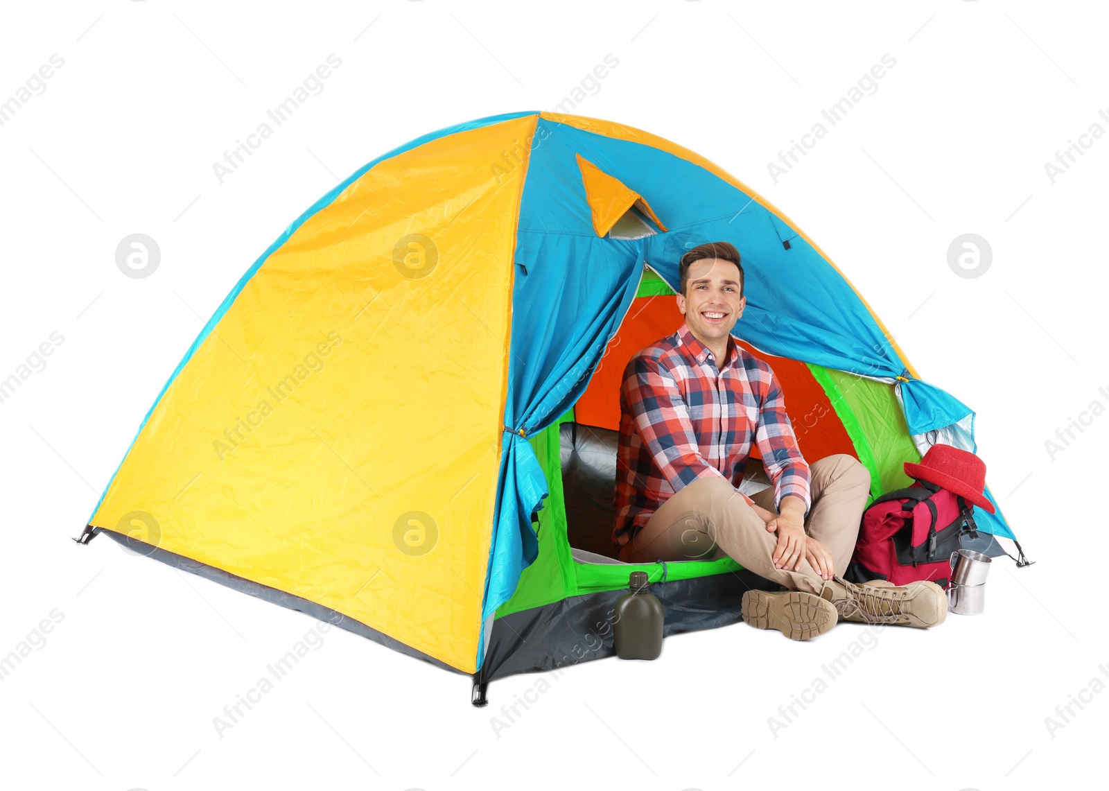 Photo of Young handsome man sitting in tourist tent on white background