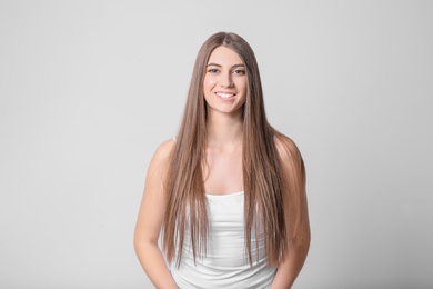 Photo of Portrait of young woman with long beautiful hair on light background