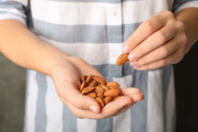 Photo of Woman holding organic almond nuts in hands, closeup